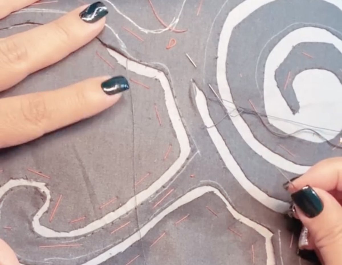 Hand stitching on the cut-through appliqué of Cultural Code
