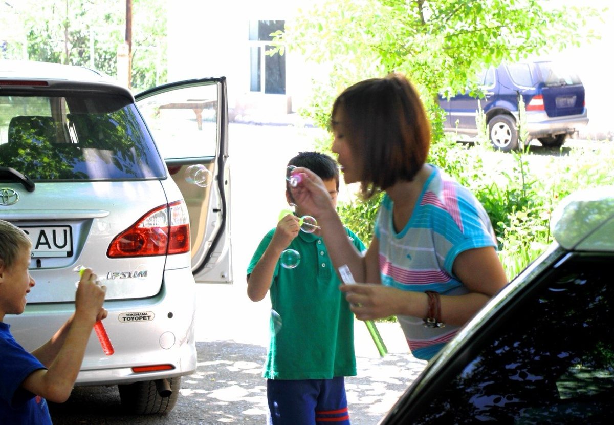 Children blowing soap bubbles in a yard