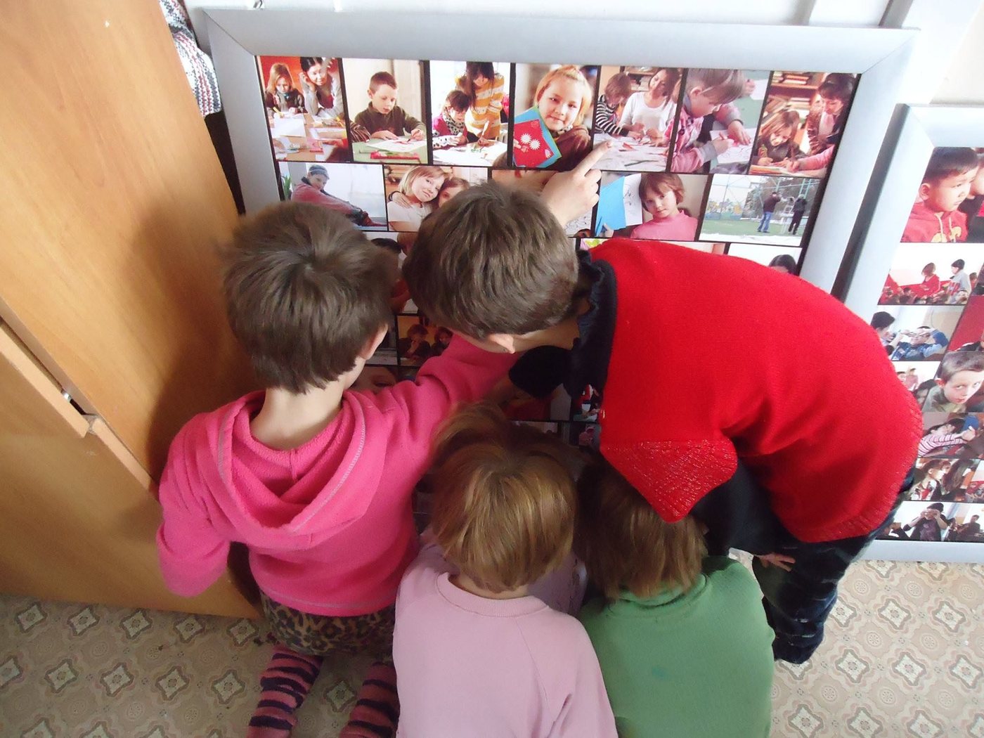 Children looking at panels of photographs they made themselves